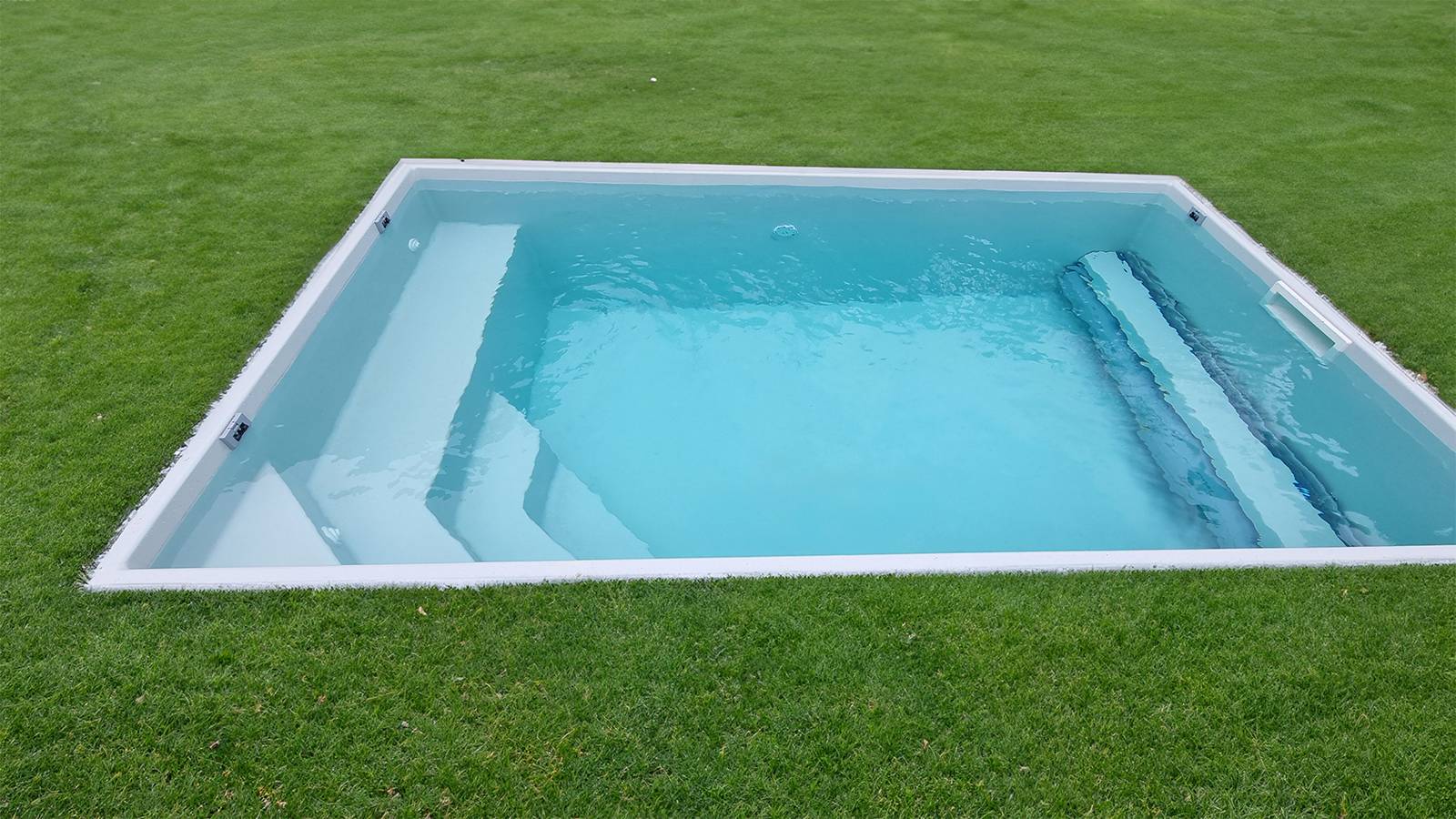 PISCINE COQUE POLYESTER AVEC COUVERTURE AUTOMATIQUE IMMERGÉE EN FOND MODÈLE TANNA