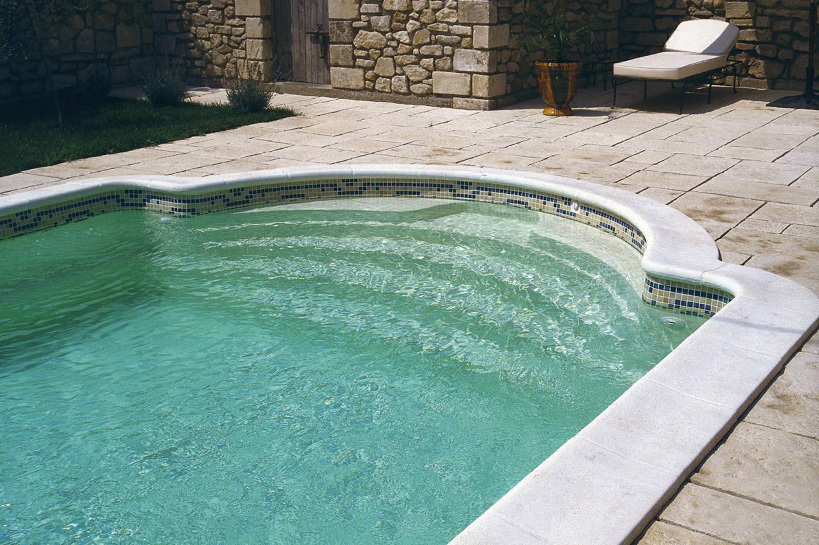 Piscine coque polyester avec escalier roman et banquette à Beaucaire dans le Gard