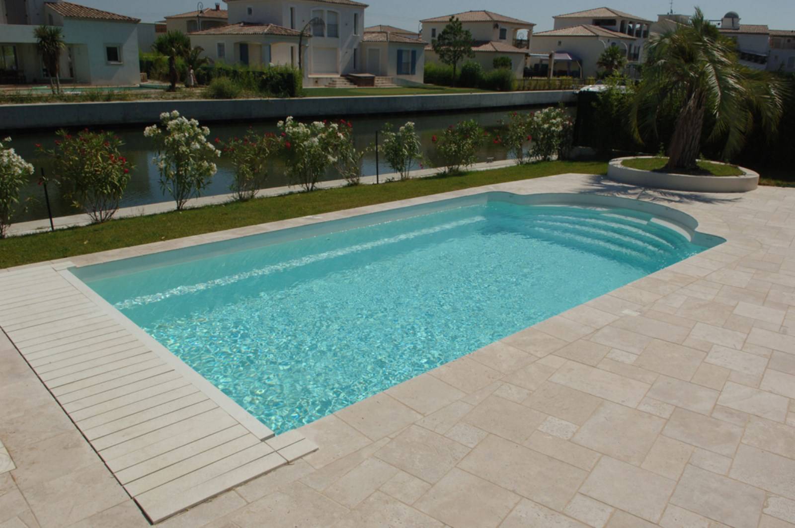 Piscine coque polyester modèle Maldives avec couverture automatique immergée dans le gard