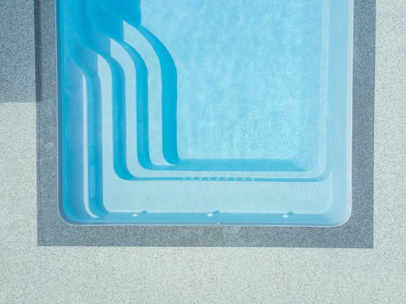 PISCINE COQUE POLYESTER RECTANGULAIRE AVEC ESCALIER D'ANGLE ET BANQUETTE MODÈLE BERMUDES