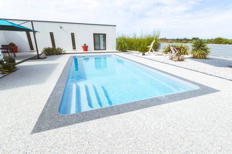 PISCINE COQUE POLYESTER RECTANGULAIRE AVEC ESCALIER D'ANGLE ET BANQUETTE MODÈLE BERMUDES