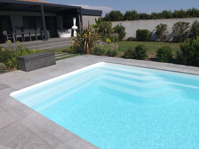 PISCINE COQUE POLYESTER ESCALIER D'ANGLE ET BANQUETTE MODÈLE BALI