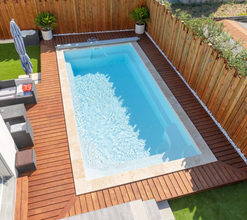 PISCINE COQUE POLYESTER FOND EN PENTE DOUCE AVEC ESCALIER D'ANGLE ET BANQUETTE MODÈLE MOORÉA