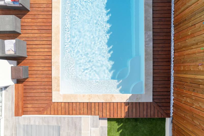 PISCINE COQUE POLYESTER FOND EN PENTE DOUCE AVEC ESCALIER D'ANGLE ET BANQUETTE MODÈLE MOORÉA