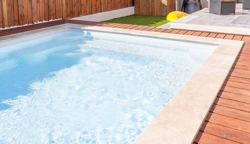 PISCINE COQUE POLYESTER FOND EN PENTE DOUCE AVEC ESCALIER D'ANGLE ET BANQUETTE MODÈLE MOORÉA