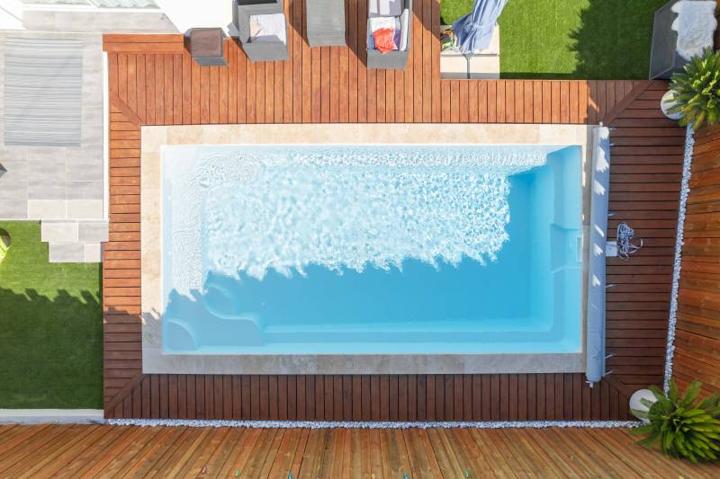 PISCINE COQUE POLYESTER FOND EN PENTE DOUCE AVEC ESCALIER D'ANGLE ET BANQUETTE MODÈLE MOORÉA