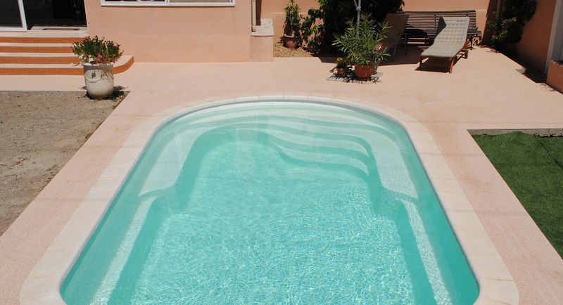 Piscine coque polyester avec banquette et escalier moderne sur Bordeaux